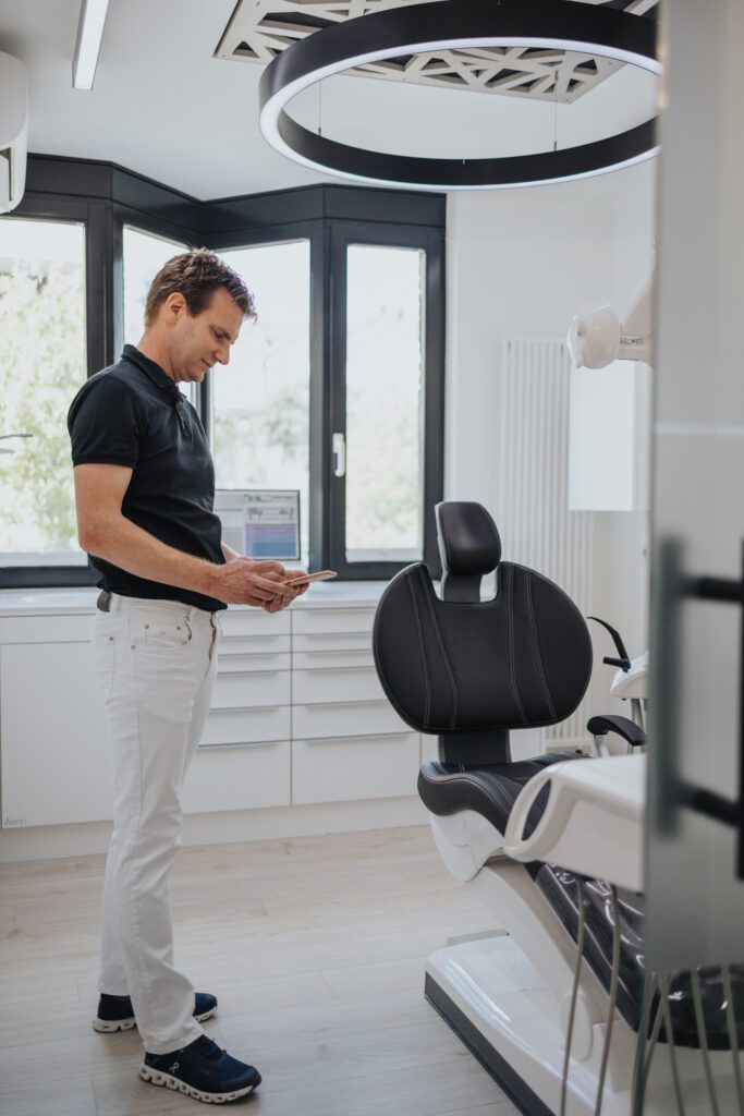 Zahnarzt Dr. Fritz Kollmar bei der digitalen Behandlungsplanung an einem Tablet in seinem modernen Behandlungsraum in Kassel.